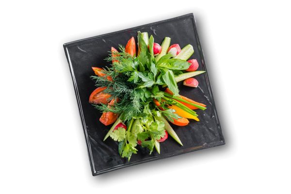 Тарелка свежих овощей с зеленью