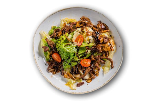 Листья салатов романо и айсберг с обжаренными кусочками говяжьей вырезки и шампиньонами с соево-медовым соусом